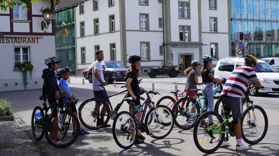 Eine Gruppe von Kindern mit Fahrrädern vor dem Gemeindehaus Bläuacker.
